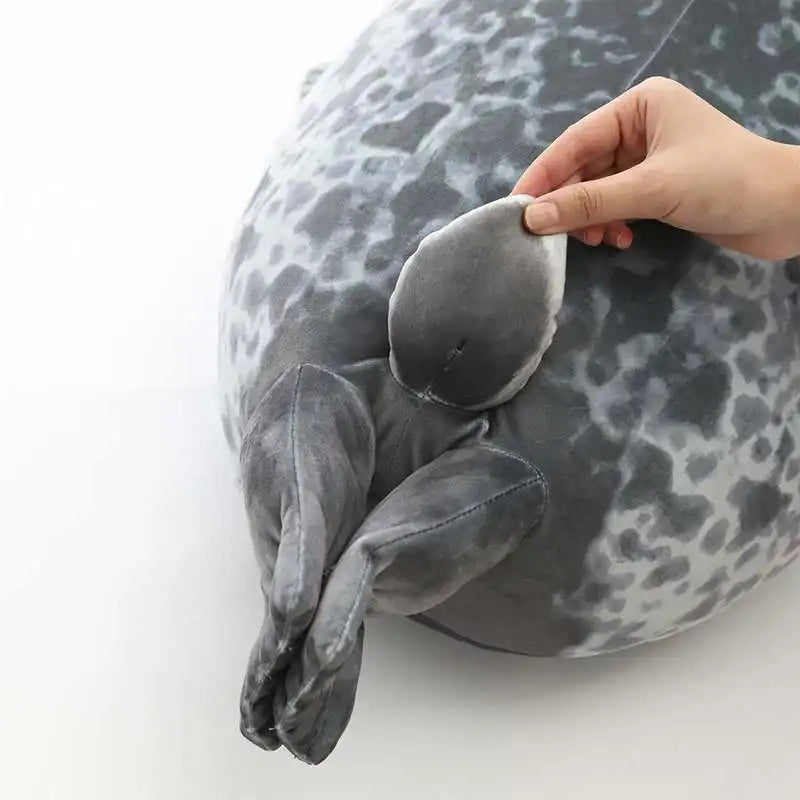 Seal plush used as a cuddly cushion on a sofa