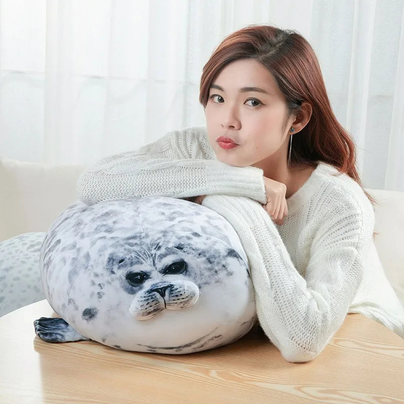 Chubby seal plush pillow resting on a bed