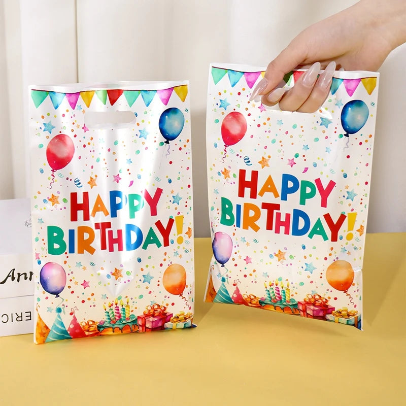 Happy birthday party gift bags with balloon print lined up together