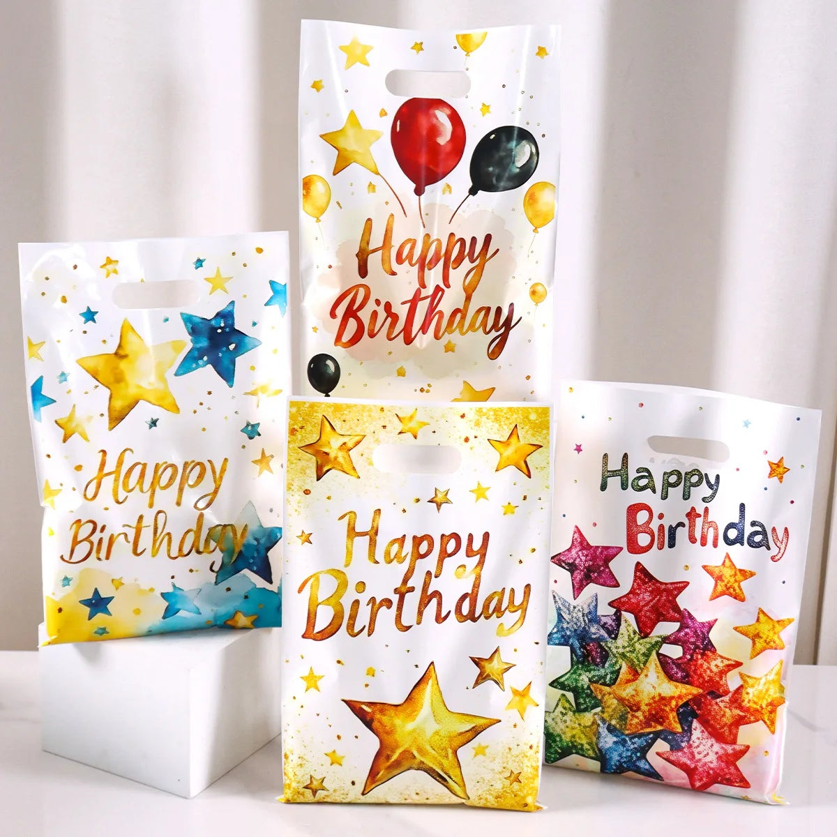 Several happy birthday party gift bags in assorted colors displayed side by side